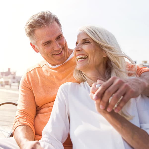Dental Services Older Couple Laughing on a Bench